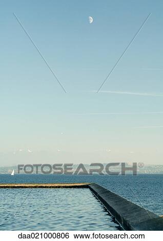 Seascape with breakwater in foreground and sailboat in distance View Large Photo Image Stock Photograph - Seascape with breakwater in foreground and sailboat in distance. Fotosearch