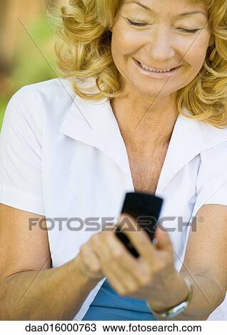 Senior woman dialing cell phone, smiling View Large Photo Image Stock Image - Senior woman dialing cell phone, smiling. Fotosearch