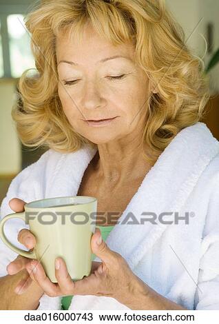 Senior woman in bathrobe holding mug View Large Photo Image Stock Image - Senior woman in bathrobe holding mug. Fotosearch