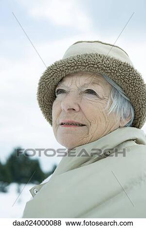 Stock Photo - Senior woman in snowy landscape, head and shoulders, portrait. Fotosearch