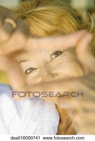 Senior woman looking at camera through finger frame View Large Photo Image Stock Image - Senior woman looking at camera through finger frame. Fotosearch