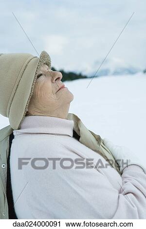 Senior woman standing in snowy landscape, looking up, waist up View Large Photo Image Stock Image - Senior woman standing in snowy landscape, looking up, waist up. Fotosearch