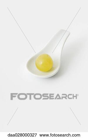 Stock Photo - Single green grape in spoon. Fotosearch