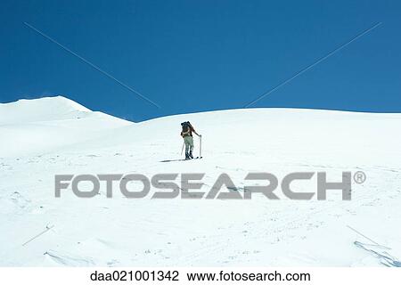 Skier going uphill, rear view View Large Photo Image Stock Image - Skier going uphill, rear view. Fotosearch