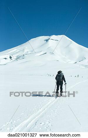 Skier heading toward mountain, rear view View Large Photo Image Stock Photo - Skier heading toward mountain, rear view. Fotosearch