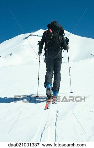 Skier heading toward mountain, rear view View Large Photo Image Stock Photo - Skier heading toward mountain, rear view. Fotosearch