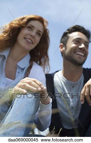 Smiling man and woman sitting side by side View Large Photo Image Stock Photography - Smiling man and woman sitting side by side. Fotosearch