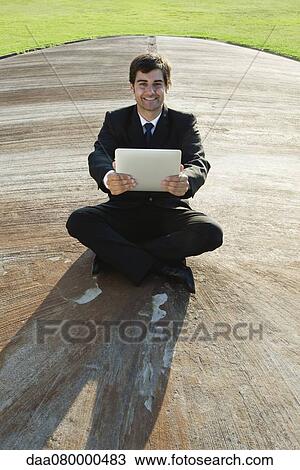 Smiling young businessman with digital tablet outdoors View Large Photo Image Stock Image - Smiling young businessman with digital tablet outdoors. Fotosearch