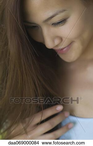 Smiling young woman looking down View Large Photo Image Picture - Smiling young woman looking down. Fotosearch