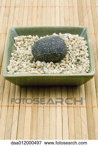 Stock Photo - Square dish containing gravel and smooth stone. Fotosearch
