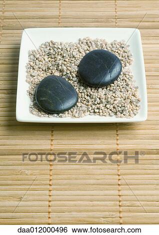 Stock Photograph - Square dish containing gravel and smooth stones. Fotosearch