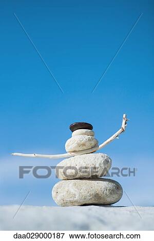 Stock Photo - Stacked coral, pebbles, and twig, close-up. Fotosearch