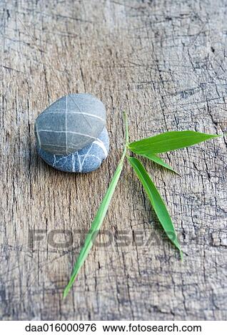 Stacked pebbles, leaf and wood View Large Photo Image Stock Photograph - Stacked pebbles, leaf and wood. Fotosearch