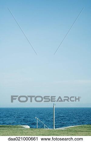 Stock Image - Steps leading to body of water. Fotosearch