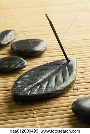 Stick of incense burning in incense holder and smooth black stones View Large Photo Image Stock Image - Stick of incense burning in incense holder and smooth black stones. Fotosearch