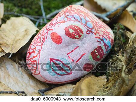 Stone decorated with face, lying on ground View Large Photo Image Stock Image - Stone decorated with face, lying on ground. Fotosearch