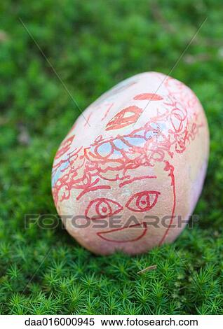 Stone decorated with face, lying on ground View Large Photo Image Stock Photography - Stone decorated with face, lying on ground. Fotosearch
