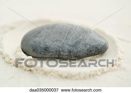 Stone on sand, close-up View Large Photo Image Stock Photo - Stone on sand, close-up. Fotosearch
