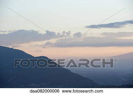 Stock Photograph - Sun rising over valley. Fotosearch