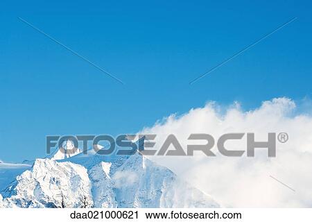 Switzerland, clouds moving over snowy mountains View Large Photo Image Stock Image - Switzerland, clouds moving over snowy mountains. Fotosearch