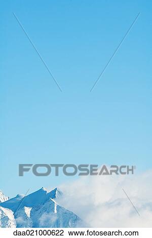 Switzerland, clouds moving over snowy mountains View Large Photo Image Stock Image - Switzerland, clouds moving over snowy mountains. Fotosearch
