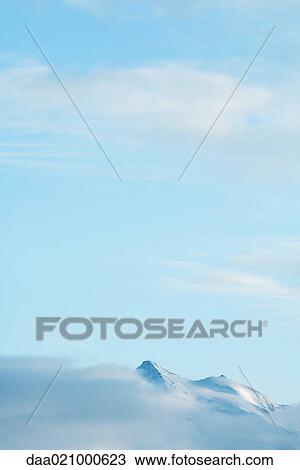 Stock Image - Switzerland, clouds moving over snowy mountains. Fotosearch