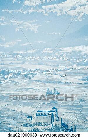 Stock Photo - Switzerland, Valais canton, airplane flying over town of Sion, Castle Valere in foreground. Fotosearch