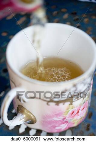 Tea being poured into tea cup View Large Photo Image Stock Image - Tea being poured into tea cup. Fotosearch