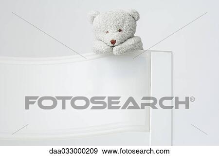 Teddy bear hanging off the back of a chair View Large Photo Image Stock Photo - Teddy bear hanging off the back of a chair. Fotosearch