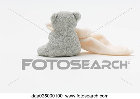 Stock Image - Teddy bear holding blanket, rear view. Fotosearch