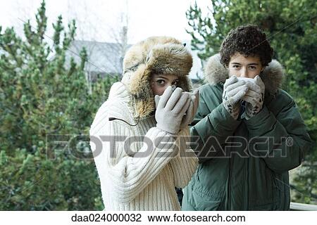 Teen boy and girl in winter clothes drinking warm drinks View Large Photo Image Stock Image - Teen boy and girl in winter clothes drinking warm drinks. Fotosearch