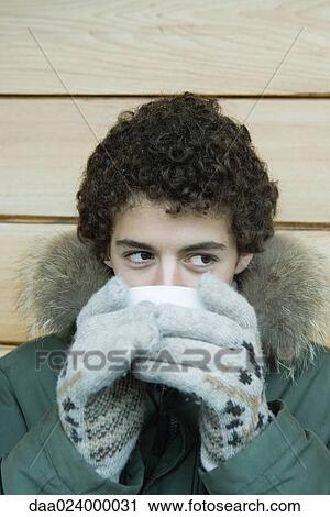 Teen boy in winter clothes drinking warm drink View Large Photo Image Stock Image - Teen boy in winter clothes drinking warm drink. Fotosearch