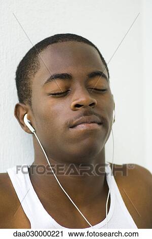 Teen boy listening to earphones, eyes closed, portrait View Large Photo Image Stock Image - Teen boy listening to earphones, eyes closed, portrait. Fotosearch