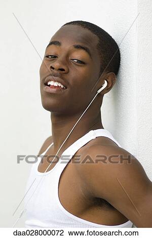Teen boy listening to earphones, looking at camera, portrait View Large Photo Image Stock Image - Teen boy listening to earphones, looking at camera, portrait. Fotosearch