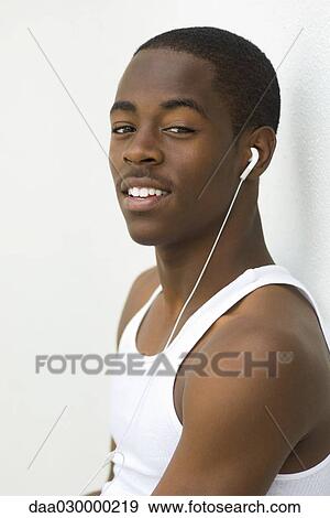 Teen boy listening to earphones, smiling at camera, portrait View Large Photo Image Stock Photo - Teen boy listening to earphones, smiling at camera, portrait. Fotosearch