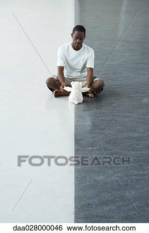 Teen boy sitting on floor, playing with stuffed toy View Large Photo Image Stock Photograph - Teen boy sitting on floor, playing with stuffed toy. Fotosearch