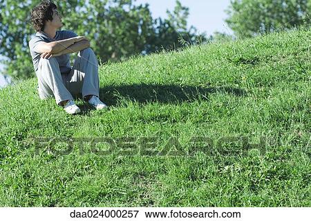 Teen boy sitting on grassy hill, relaxing View Large Photo Image Stock Photo - Teen boy sitting on grassy hill, relaxing. Fotosearch