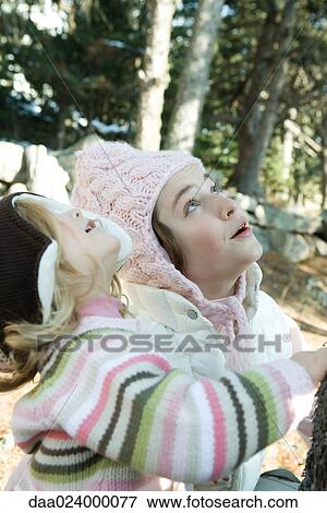 Stock Photo - Teen girl and toddler, in woods, looking up together. Fotosearch