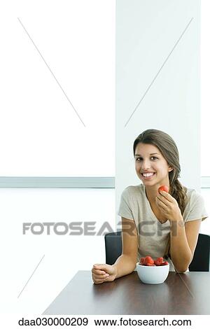 Teen girl eating strawberries, smiling at camera View Large Photo Image Stock Photo - Teen girl eating strawberries, smiling at camera. Fotosearch