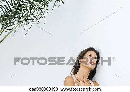 Teen girl leaning against wall with hand on chest, looking up View Large Photo Image Stock Photo - Teen girl leaning against wall with hand on chest, looking up. Fotosearch