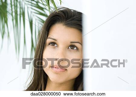 Teen girl looking up, palm leaf in background View Large Photo Image Stock Image - Teen girl looking up, palm leaf in background. Fotosearch