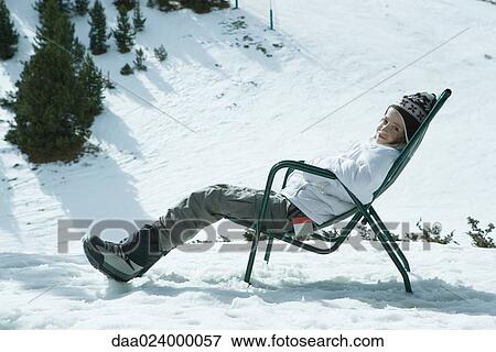 Teen girl sitting in chair in snowy landscape, relaxing in sun View Large Photo Image Stock Photo - Teen girl sitting in chair in snowy landscape, relaxing in sun. Fotosearch