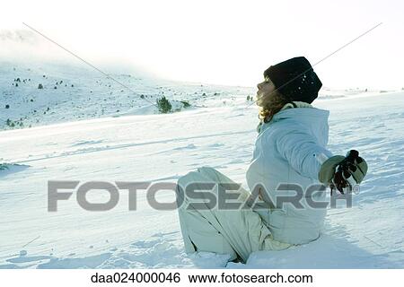 Teen girl sitting on snow, eyes closed and arms out to sides View Large Photo Image Stock Photograph - Teen girl sitting on snow, eyes closed and arms out to sides. Fotosearch