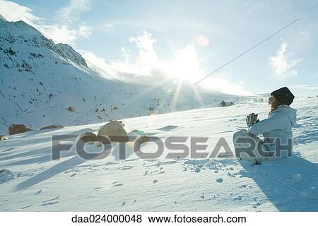 Teen girl sitting on snow in prayer position, sun shining over edge of mountain View Large Photo Image Stock Photo - Teen girl sitting on snow in prayer position, sun shining over edge of mountain. Fotosearch
