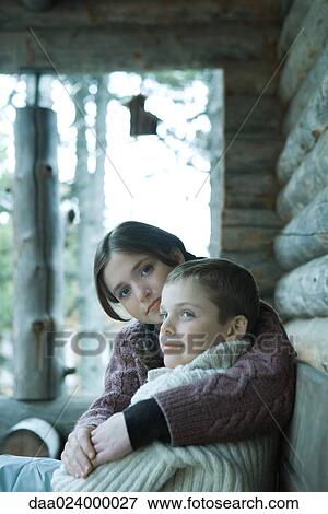 Teen girl sitting with arm around younger brother, both wearing warm sweaters View Large Photo Image Stock Photo - Teen girl sitting with arm around younger brother, both wearing warm sweaters. Fotosearch