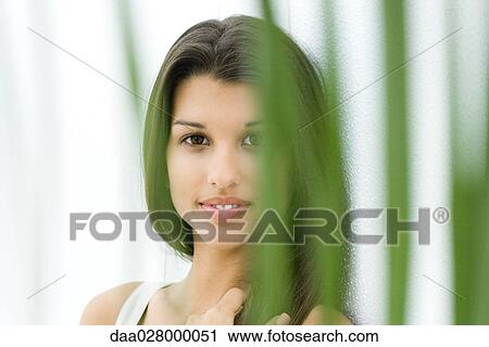 Teen girl, smiling at camera through foliage View Large Photo Image Stock Image - Teen girl, smiling at camera through foliage. Fotosearch