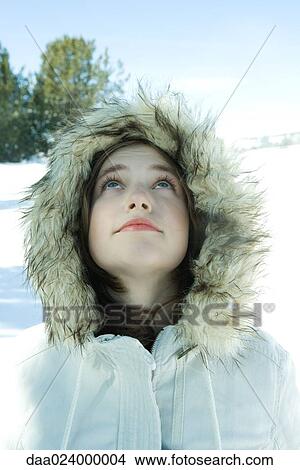 Teen girl wearing parka in snow, looking up View Large Photo Image Picture - Teen girl wearing parka in snow, looking up. Fotosearch