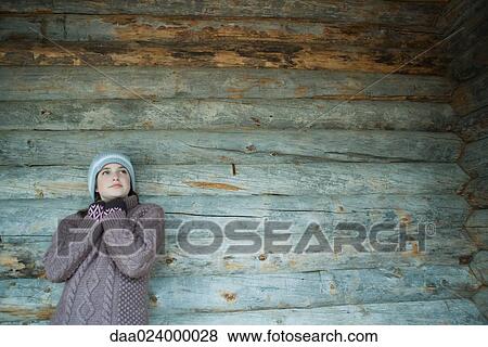 Teen girl wearing warm clothes, leaning against log cabin View Large Photo Image Stock Photo - Teen girl wearing warm clothes, leaning against log cabin. Fotosearch