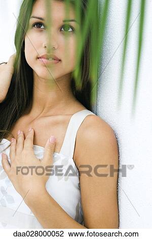 Teen girl with hand on chest, looking up, foliage in foreground View Large Photo Image Stock Image - Teen girl with hand on chest, looking up, foliage in foreground. Fotosearch