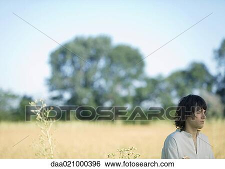 Teenage boy standing in field View Large Photo Image Stock Photograph - Teenage boy standing in field. Fotosearch